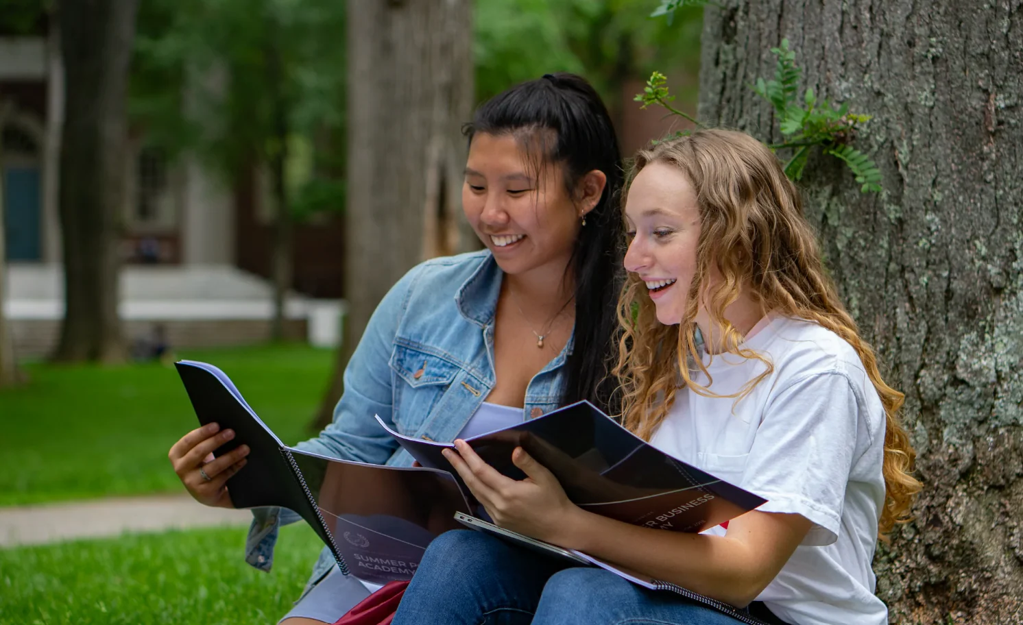 Two students reading and discussing their work on campus